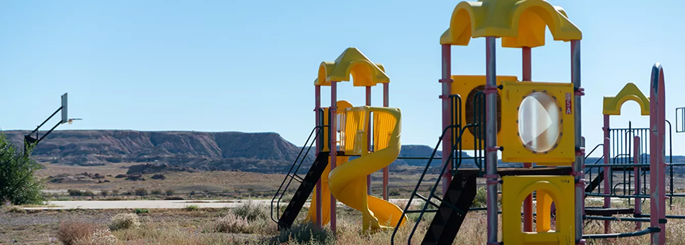 Lake Valley playground with slides and basketball hop. A scenic view of the mountains in the background of the playground. 