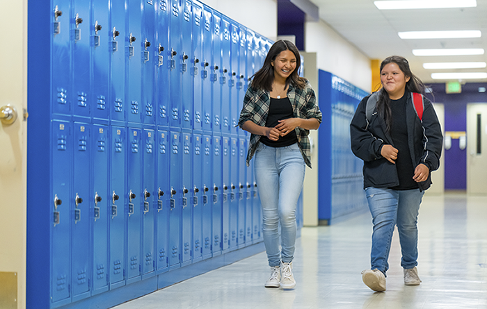 Two students walking the school hallway.